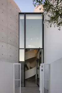 A modern residential entryway featuring glass and concrete materials.