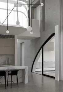 Modern kitchen with concrete walls, marble countertops, and minimalist design.