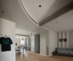 A modern kitchen with a concrete countertop, wooden cabinets, and a concrete couch beside it.