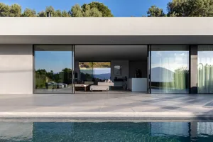 Modern minimalist residential space with large glass walls and a clean, contemporary design.