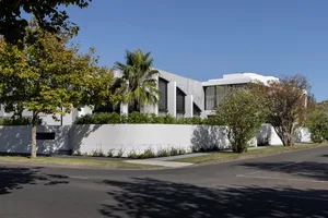 A modern minimalist house exterior made of white concrete and glass, featuring clean lines and a contemporary design.
