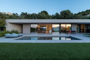 A modern residential home with a concrete facade and a pool in the backyard.