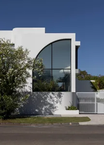 A modern house with a white exterior and large glass facade.
