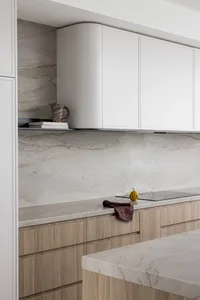 Modern kitchen featuring minimalist design with marble countertops and cabinets.