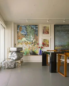 A modern home office with an art collection featuring abstract paintings and sculptures.
