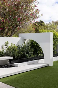 Concrete lawn planter with greenery and a water feature.