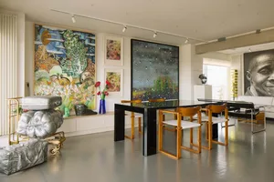 A modern living room with glass and wood furniture, colorful artwork, and a sleek table.