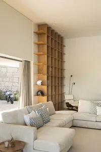 A modern living room featuring a large, wooden bookshelf.