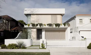 A modern residential exterior with white paint and concrete features.