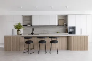 Contemporary residential kitchen featuring a marble countertop and bar stools.