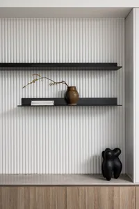 Modern shelves with metal shelves, a vase, a book, and a statue on a ribbed wall background.