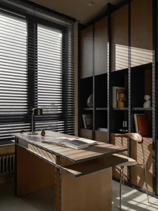 Modern home office with industrial design, featuring a wooden desk and bookshelf.