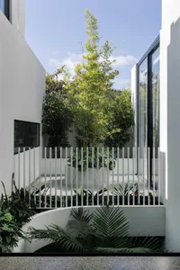 Modern interior and exterior of a residential house featuring a minimalist design with concrete walls and large glass windows