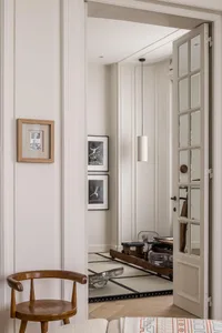 A modern home office featuring wooden shelves with glass and metal elements.