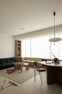 Minimalist living room with a concrete floor, wood furniture, and floor-to-ceiling windows.