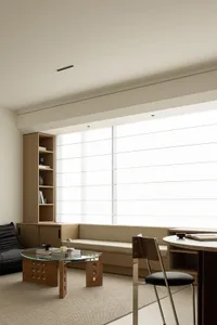 Minimalist living room with wood furniture, white walls, and large windows.
