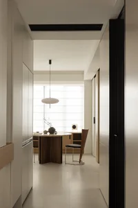 A modern dining room with a wooden table and white chairs, featuring a minimalist design and contemporary style.