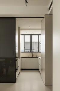 Modern minimalist kitchen with white cabinets and sleek design.