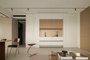 A minimalist kitchen featuring wood and white cabinets and countertops.
