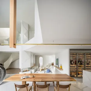 Modern minimalist living space with white walls, wooden furniture, and contemporary decor.