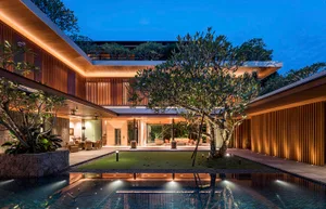 A modern residential design featuring a wooden outdoor space with a pool and lush greenery.