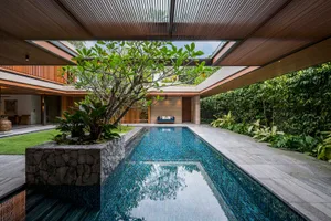 Modern residential interior featuring glass, concrete, and wooden elements.