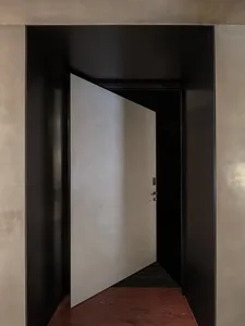 A modern entrance featuring a metallic grey panel, open to reveal an enclosed space.