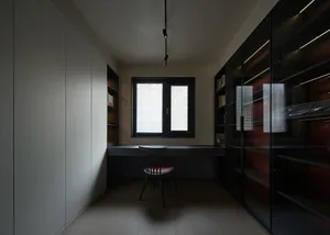 A modern home office featuring glass walls and wooden furniture.