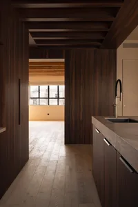 Modern kitchen interior with wooden flooring and cabinetry.
