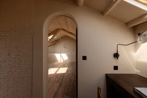 A modern loft office featuring a brick-clad ceiling and wooden flooring.