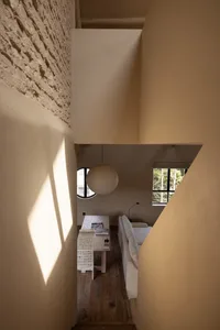 A modern minimalist living room with concrete walls and wooden furniture.