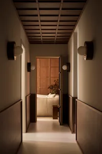 A minimalist hallway with wooden paneling and warm lighting.
