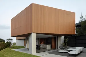 Modern residential building with a wooden wall exterior and open patio area.