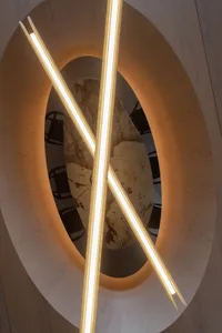 Modern art installation featuring neon light tubes and marble floor, viewed from above