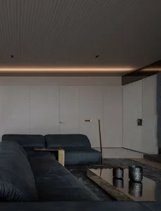 Modern living room featuring dark leather sofas and metal accents.