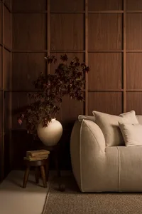 A minimalist living room featuring fabric-paneled walls and a comfortable sofa.