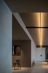 Modern residential corridor featuring light-wood paneling and a ceiling light