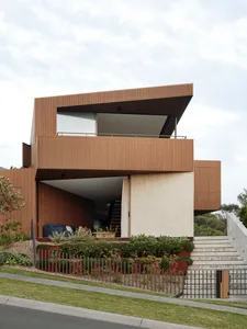 Modern residential house with wood siding, concrete steps, and minimalist architectural design.