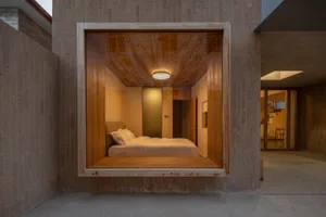 Modern minimalist bedroom with a floating platform bed made of wood, featuring a sleek design with concealed lighting and a m