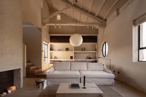 A minimalist living room featuring wooden and concrete elements.