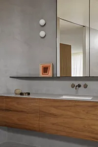 Modern minimalist bathroom with concrete walls and floating wooden vanity.