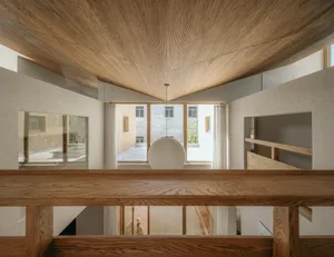 A minimalist home interior with wooden elements and concrete walls.