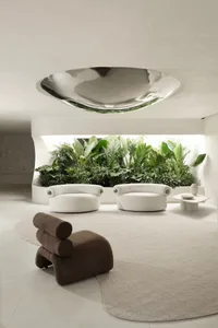 A minimalist living room featuring concrete and glass materials with green plants.