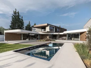 A modern house featuring concrete, glass, and wood materials.