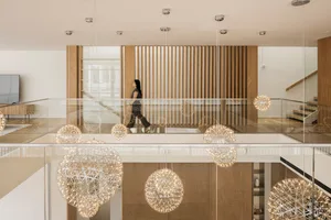 A modern interior space with metal chandeliers hanging from the ceiling.