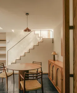 Modern interior with a wine bar, kitchen, and breakfast nook featuring wooden furniture and concrete flooring.