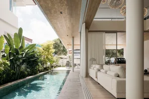 A modern living room featuring a swimming pool, marble flooring, and wooden ceiling.