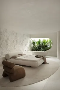 A modern minimalist bedroom with a concrete bed frame and plant-filled bathtub