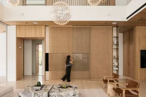 A modern minimalist living room featuring a wood sliding door and minimalist furniture.