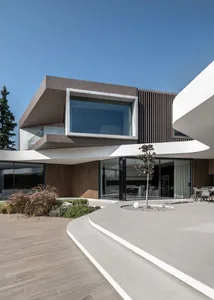 Modern residential architecture featuring concrete, glass, and wood materials, with a clean and futuristic design.